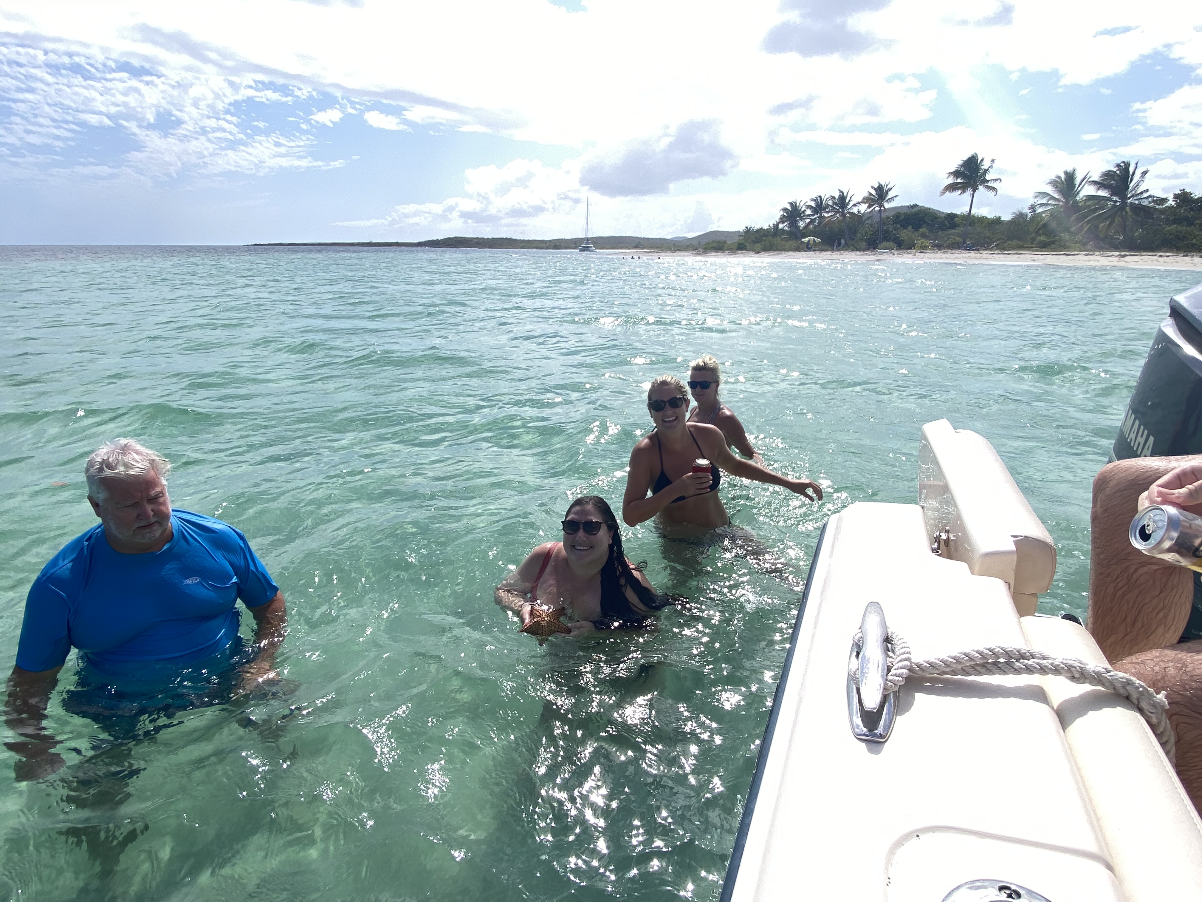 Three women in the ocean beside a Grady White boat on a Vieques boat charter