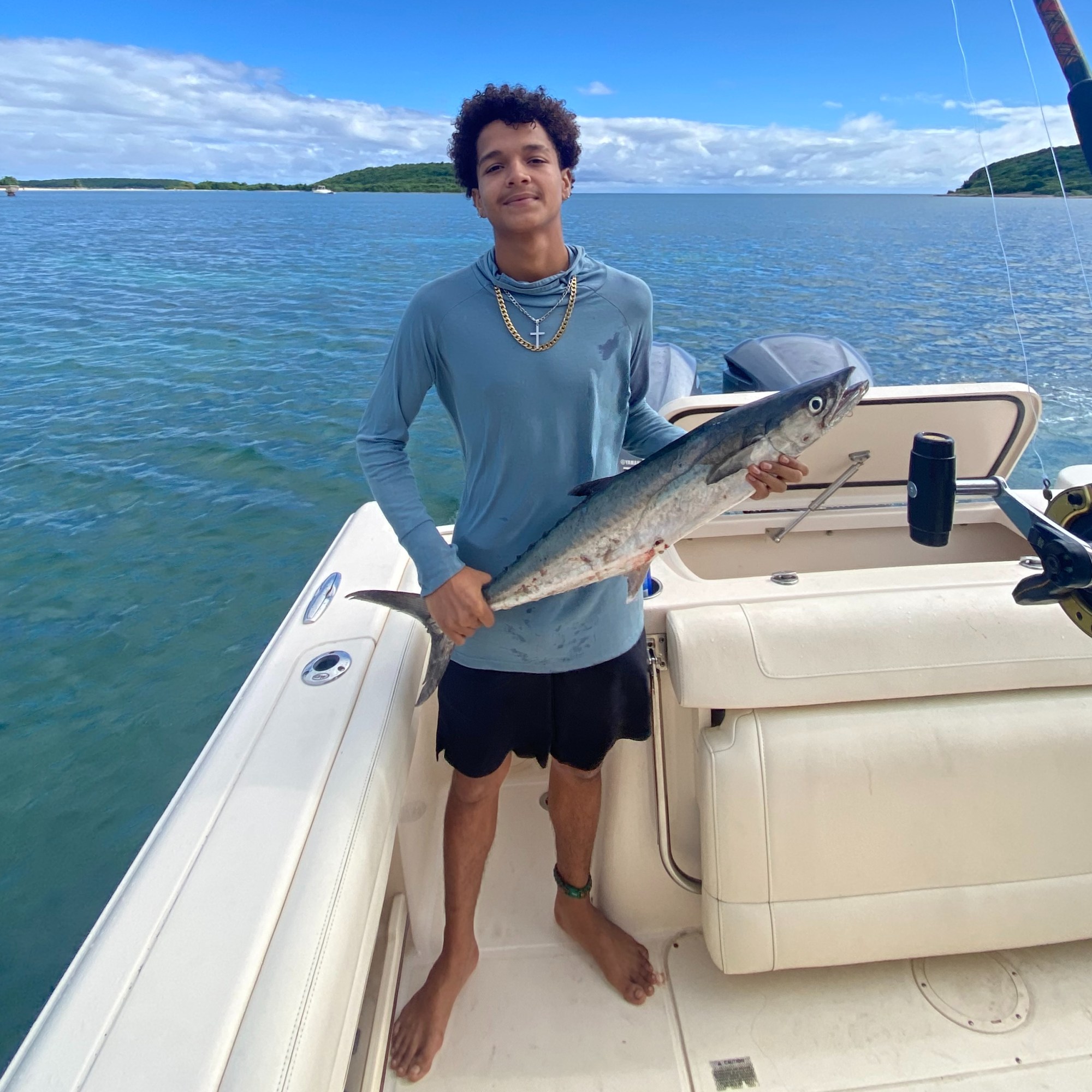 Young adult holding a barracuda on a Vieques deep sea fishing charter