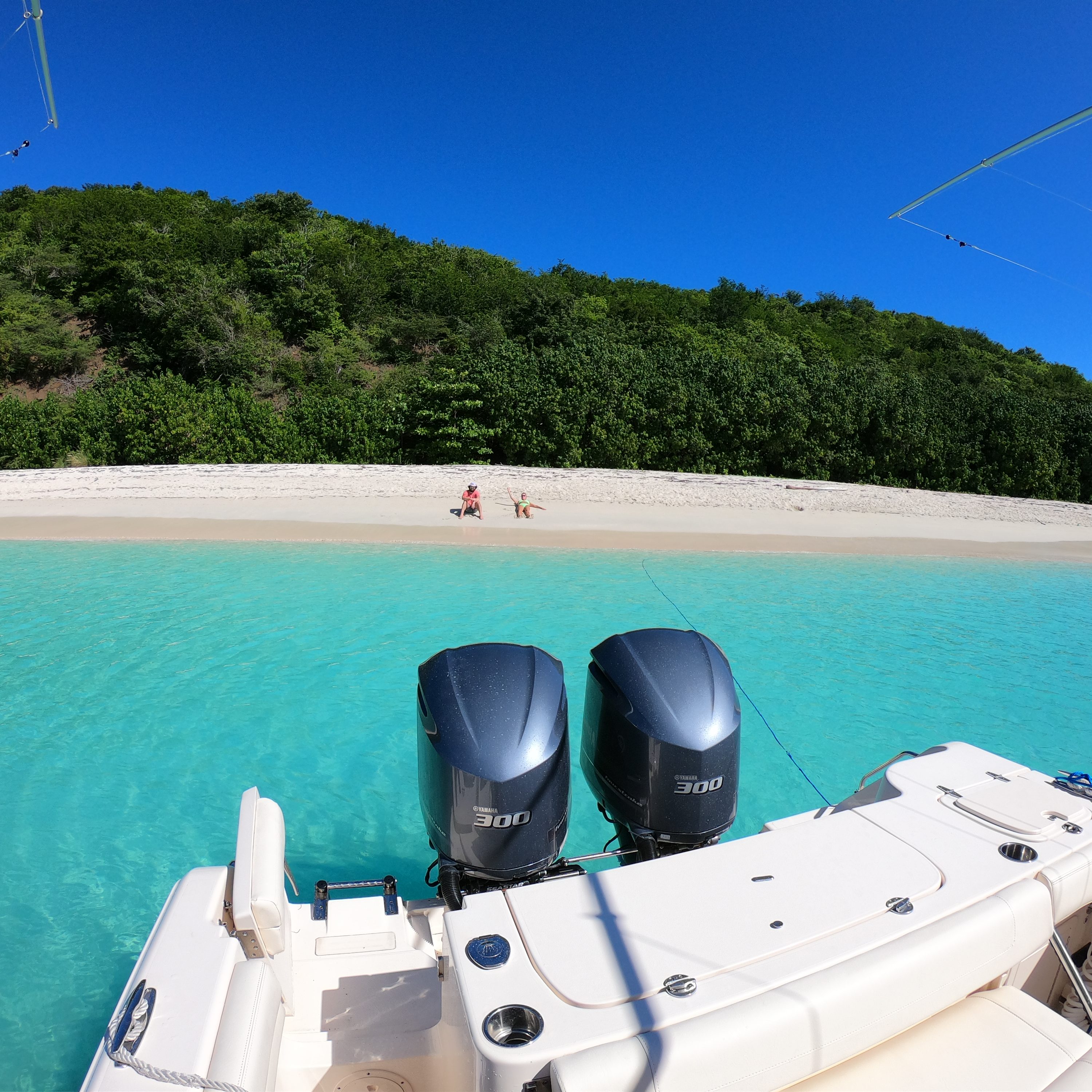 View off the boat of a Vieques charter of a couple sitting on a beach