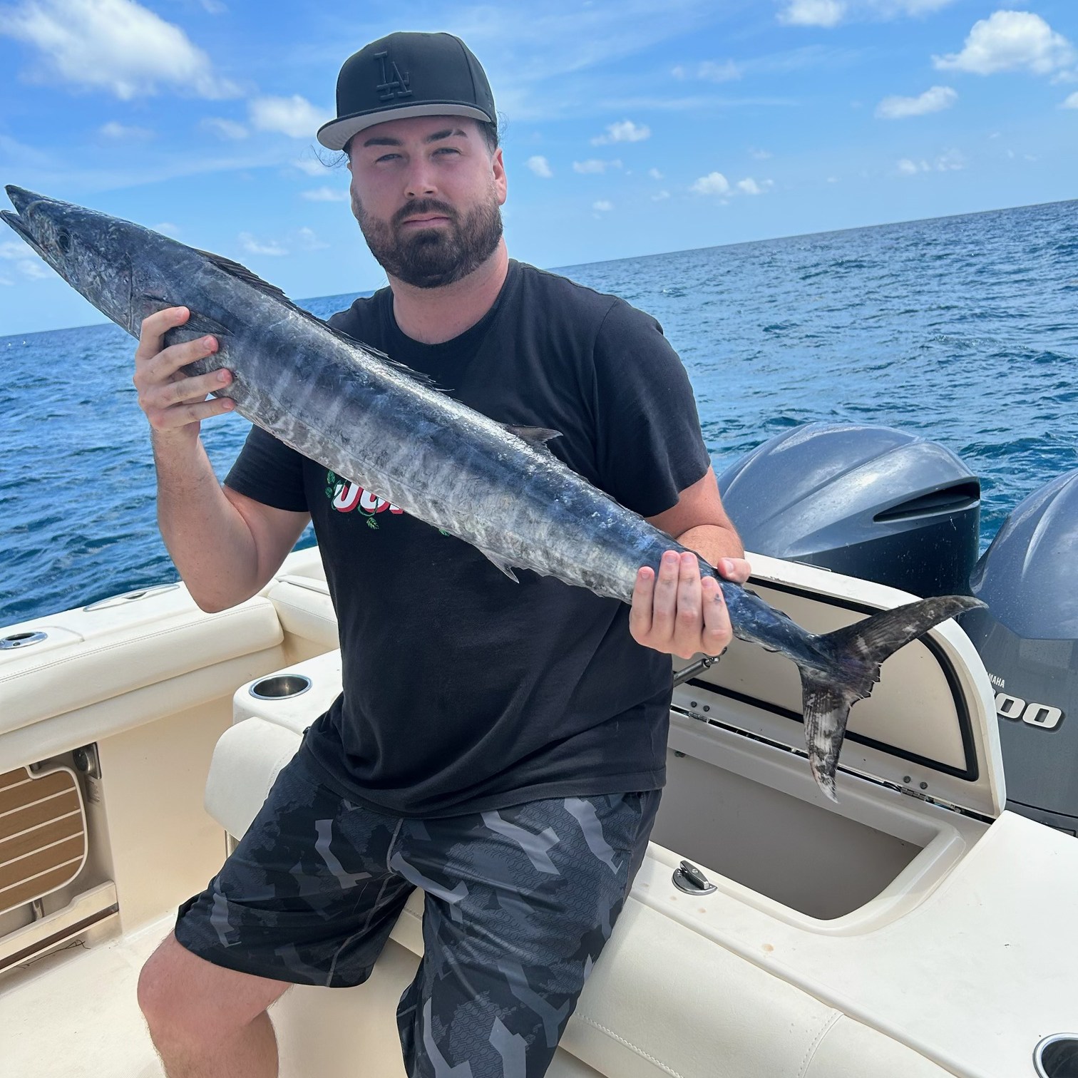 Man holding a barracuda on a Vieques deep sea fishing charter