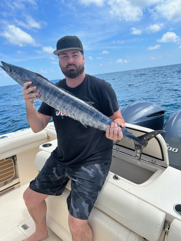 Man holding a barracuda on a Vieques deep sea fishing charter